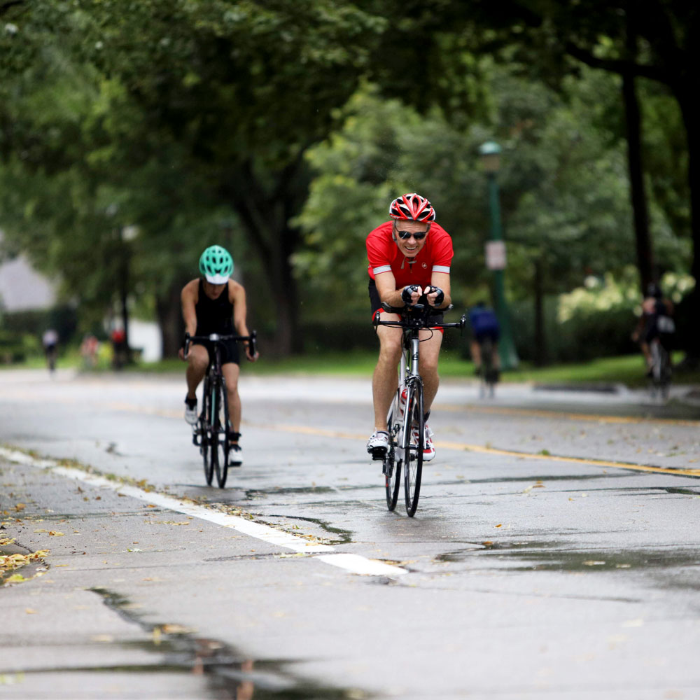 Two people riding their bikes during a triathlon.